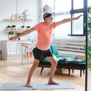 Senior man doing yoga - wellbeing and wellness concept
