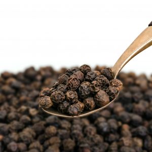 Whole Black Pepper on Old Brass Spoon
