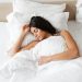 Portrait of peaceful beautiful woman sleeping alone at home in b
