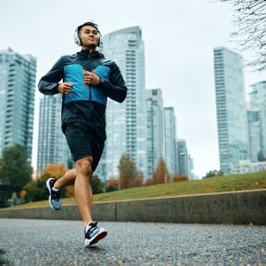 Below view of male athlete jogging in the rain.