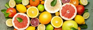 Citrus fruit food background, top view. Mix of different whole and sliced fruits