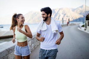Happy fit people couple jogging and running outdoors