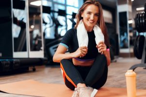 Portrait of a woman with towel working out in a gym