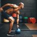 Shot of a muscular young man exercising with a kettlebell in a gym