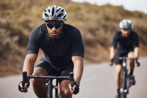 Training, energy and fitness with athlete exercise on bicycle outdoors, practice speed and enduranc