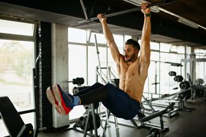 Young fit man exercising in a gym. Sport people healthy lifestyle concept
