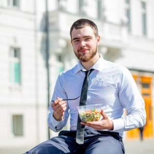 businessman in shirt and tie with salad lunch box