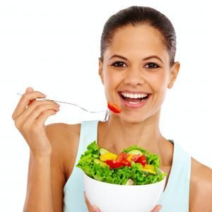 Eating healthy. Portrait of an attractive young woman eating a healthy salad.
