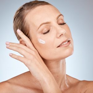 Face, skincare or woman in a studio with cream for acne, anti aging or dermatology with sunscreen o