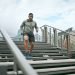 Fitness, bridge or black man running on stairs for legs training, exercise or workout in city of in