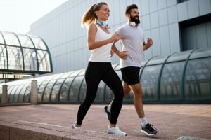 Fitness sport friendship people and lifestyle concept. Happy fit smiling couple running outdoors