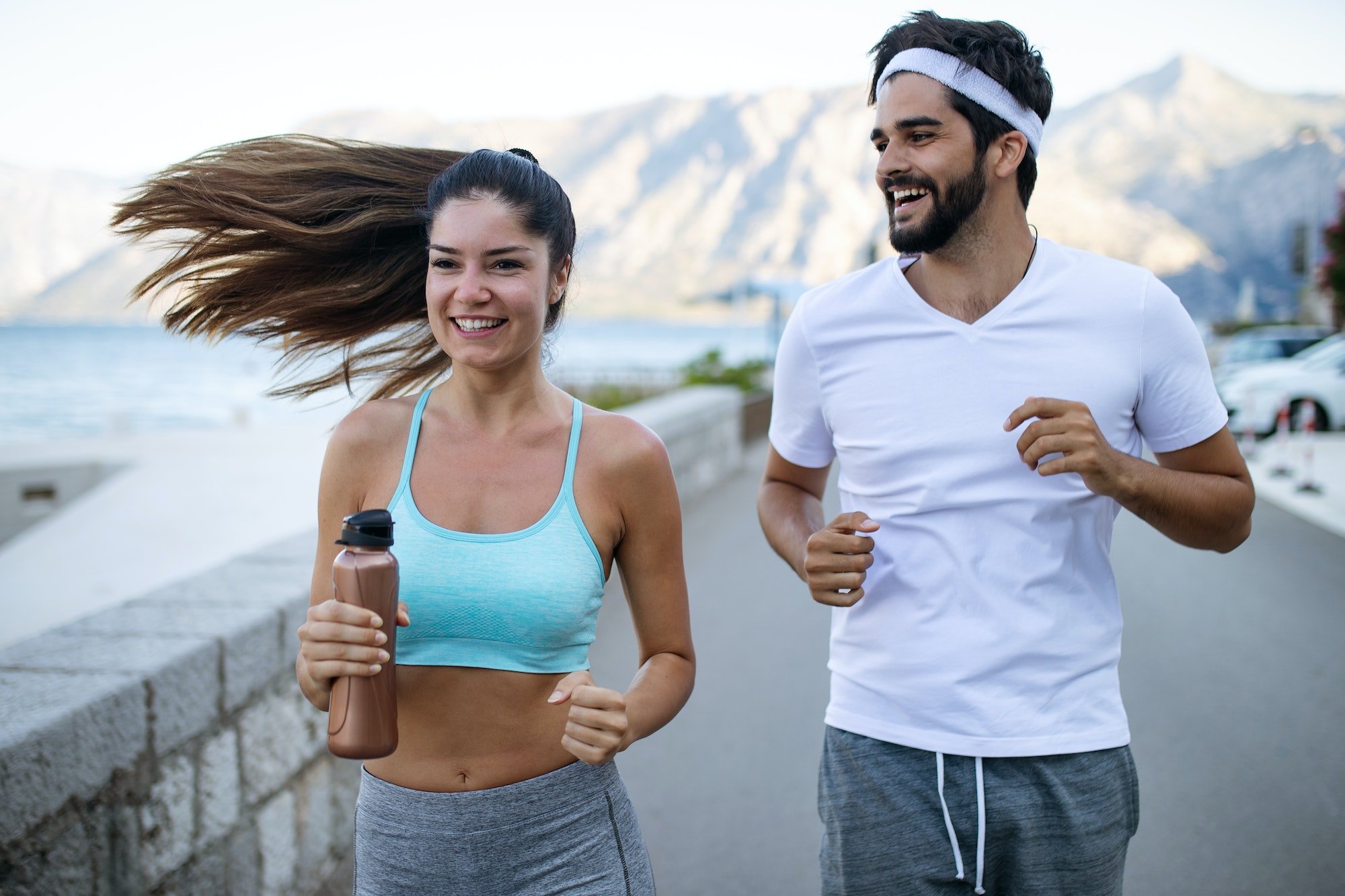 Happy young fit people couple running outdoor