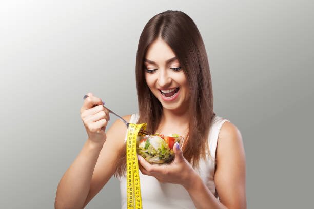 Woman. Diet. Portrait. Womens model with green salad. Adherence to the diet. Fresh Salad.