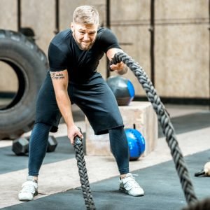 Man training with a rope in the gym