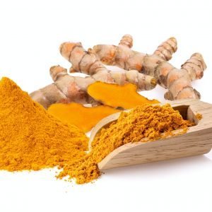 Turmeric powder in wood scoop isolated on white background