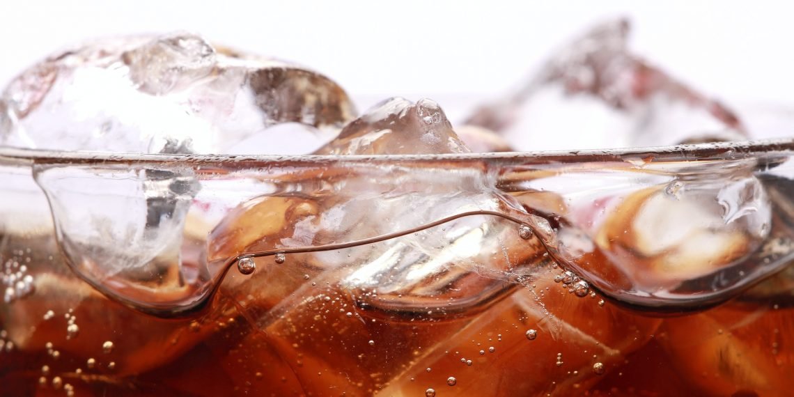 Coke in a glass with ice cubes isolated on a white background