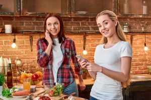 Eat good, Feel good, Look Good. Young female friends preparing together vegetarian meal in modern