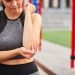 Young woman hurt elbow during workout outdoors