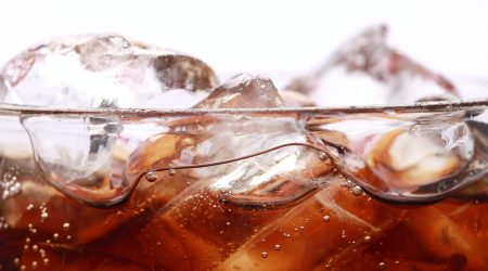 Coke in a glass with ice cubes isolated on a white background