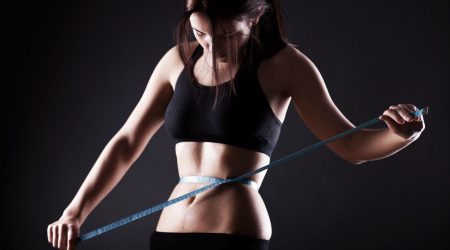 Fitness woman measuring her waist, weight loss