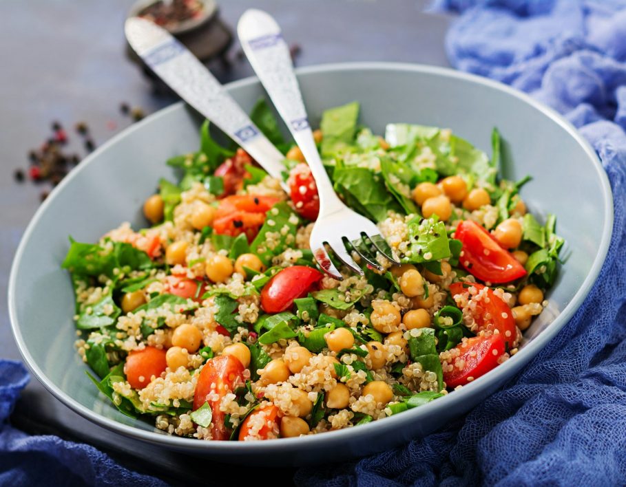 Healthy vegan salad of fresh vegetables - tomatoes, chickpeas, spinach and quinoa