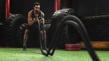 Man is making battle rope exercises during his cross training workout