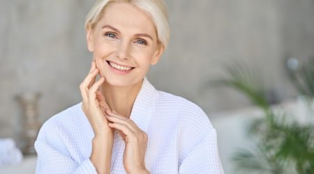 Portrait of smiling mid age woman looking at camera. Skin care concept.