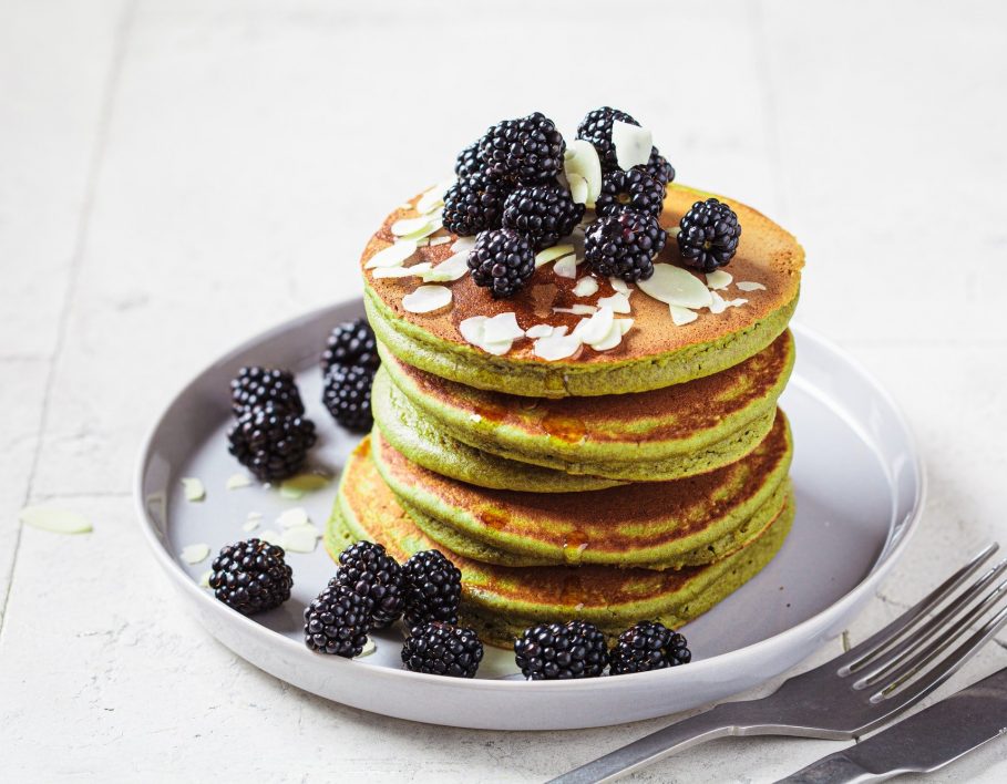 Vegan green matcha pancakes with blackberries.