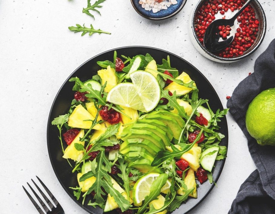 Vegan pineapple salad with fresh arugula, avocado and dried cranberry