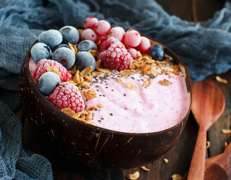 Wild berries smoothie bowls topped with frozen berries and granola