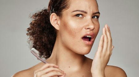 Woman, bad breath and smelling mouth for dental problem, odor and poor oral health in hand. Female